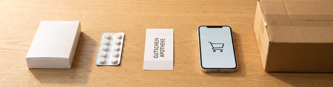 DocMorris Gutschein Ratgeber - Medikamentenschachtel, Gutschein und Versandpaket auf Holztisch