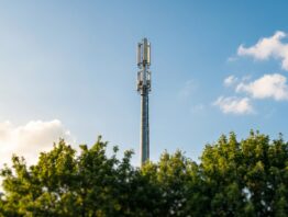 5G Mobilfunkmast mit Smartphone und 5G-Symbol in der Statusleiste
