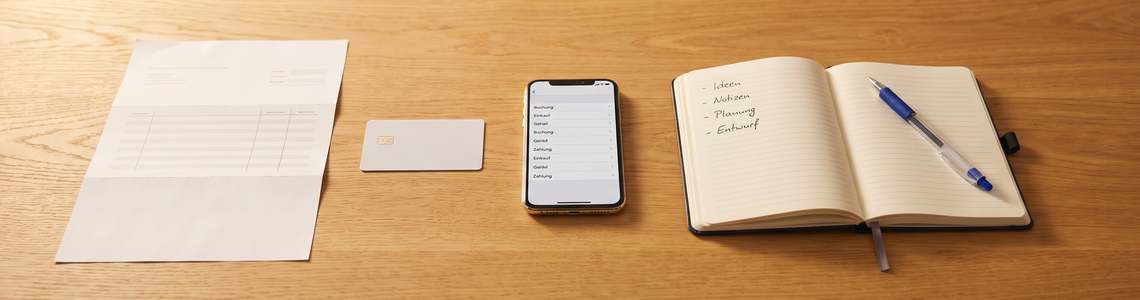 Abos verwalten: Kontoauszug, Bankkarte, Smartphone und Notizbuch auf dem Schreibtisch