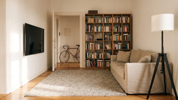 agentB hausrat inline1 Wohnzimmer mit Sofa, Regal und Fahrrad im Flur als versicherter Hausrat