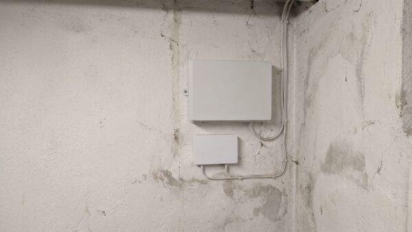 agentC glasfaser i3 Glasfaser-Hausübergabepunkt an einer Kellerwand mit angeschlossenem Netzabschlussgerät