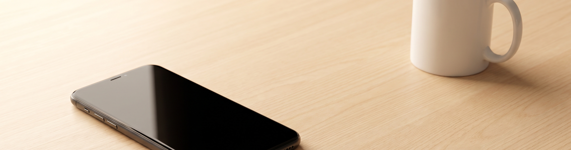 Ausgeschaltetes Smartphone auf einer hellen Holzfläche