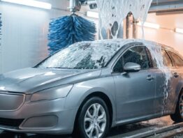 Auto in der Waschstraße mit Schaum und Textillappen