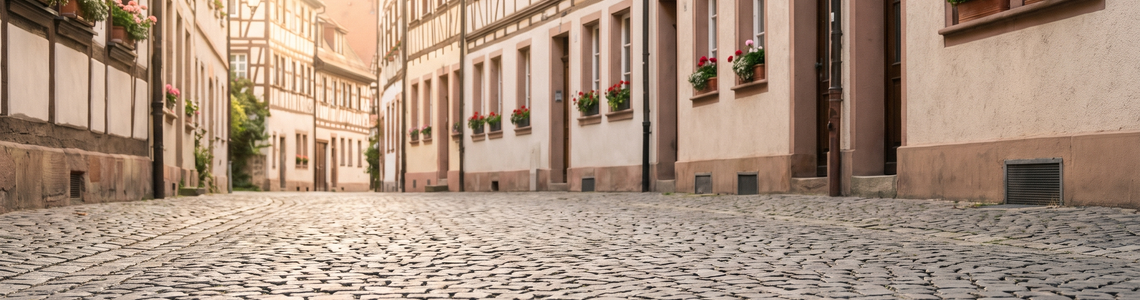 Leere gepflasterte Altstadtgasse mit hellen Fassaden