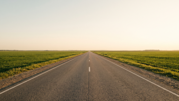 Leere Landstraße führt geradeaus in Richtung Horizont