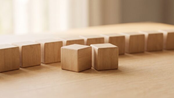 Reihe unbedruckter Holzwuerfel auf einer hellen Holzflaeche