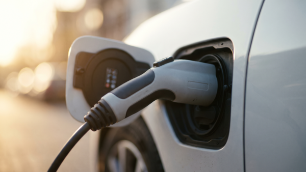elektroauto reichweite bild 1 Ladestecker in der Ladebuchse einer hellen Fahrzeugkarosserie