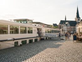 Flusskreuzfahrtschiff legt mitten in der Altstadt an der Uferpromenade an