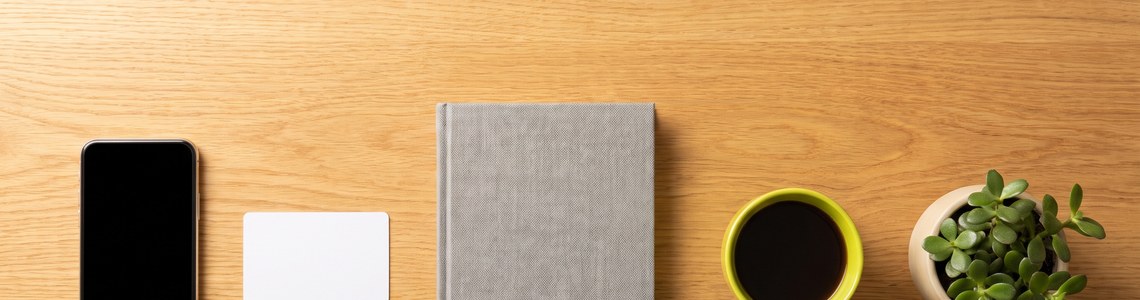 Haushaltsbuch-App: Smartphone, Bankkarte und Notizbuch auf dem Tisch