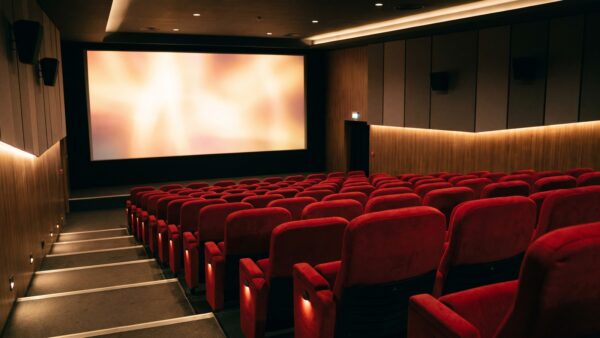 kino saal Kinosaal mit roten Sitzreihen und beleuchteter Leinwand