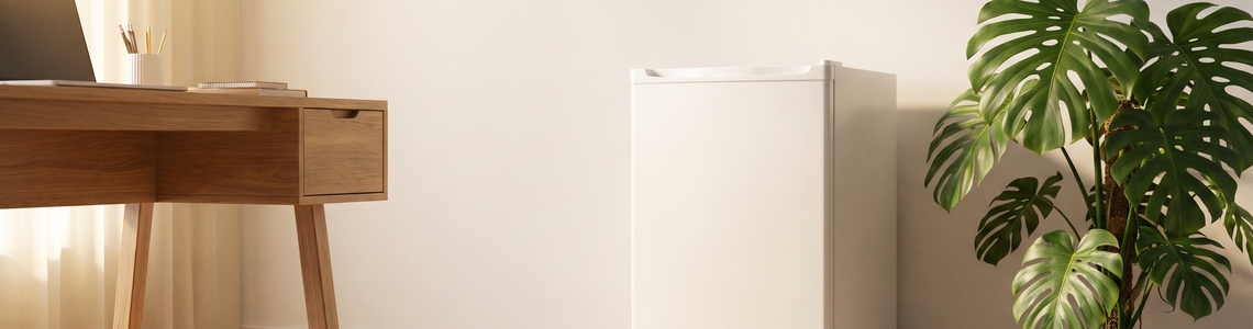 Kleiner weißer Kühlschrank ohne Aufdruck in einem hellen Arbeitszimmer