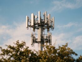 Mobilfunkmast mit Antennen vor blauem Himmel