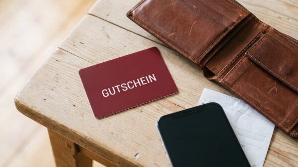 pollin insolvenz gutschein Gutscheinkarte und Geldbörse auf Holztisch — Gutscheine bei Insolvenz eines Onlineshops