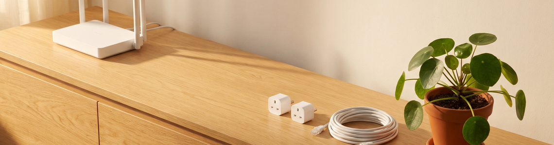 Router, Powerline-Adapter und Netzwerkkabel auf einem Sideboard