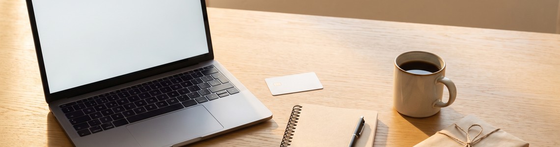 Laptop, Bankkarte und Paket auf einem Schreibtisch