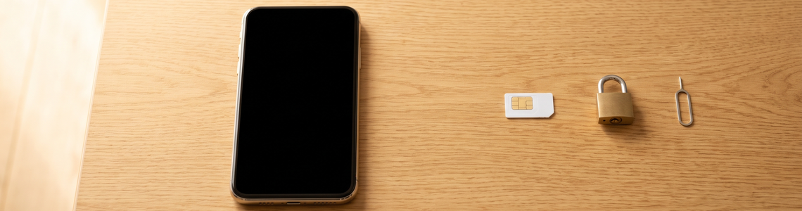 SIM-PIN: Smartphone, SIM-Karte und Vorhängeschloss auf dem Tisch