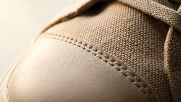 sneaker reinigen bild 1 Nahaufnahme von Textilgewebe und Lederkappe eines Sneakers