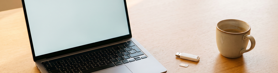Surfstick: Laptop, USB-Stick und SIM-Karte auf dem Schreibtisch