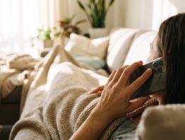 Krank auf dem Sofa und telefonisch bei der Praxis melden