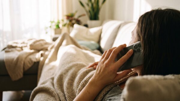 Krank auf dem Sofa und telefonisch bei der Praxis melden
