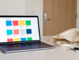 action online bestellen bild 1 Laptop mit Produktübersicht neben leerer Einkaufstasche und Schlüsselbund auf dem Küchentisch
