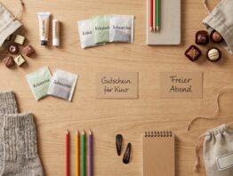 Ausgebreitete Fuellideen für einen selbst befuellten Adventskalender auf einem Holztisch