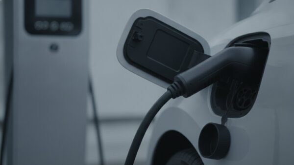 bmw ix3 bild 2 Schnellladekabel in der geöffneten Ladeklappe eines hellgrauen Elektroautos