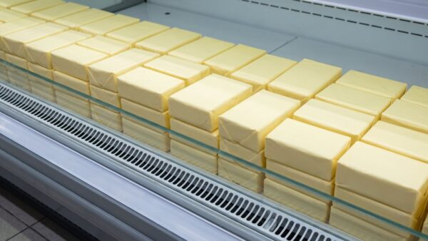 butterpreis 2026 bild 1 Kühlregal im Supermarkt mit unbedruckten Butterpäckchen und leerer Regalschiene