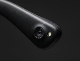 Makroaufnahme eines Brillenbügels mit winziger Linse und kleinem Leuchtpunkt