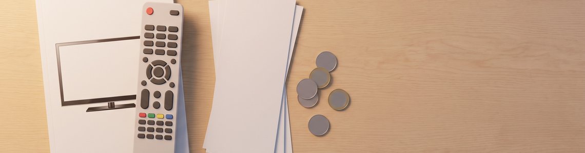 Fernbedienung, leere Belege und Münzen auf einem hellen Holztisch