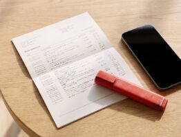Kontoauszug mit Textmarker und Smartphone auf dem Tisch