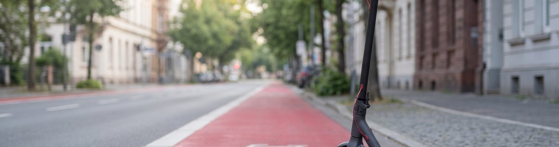 E-Scooter am Rand eines rot markierten Radwegs in einer Innenstadtstraße