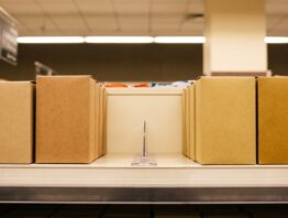 Supermarktregal mit schlichten Süßwarenschachteln und einer breiten Lücke in der Mitte