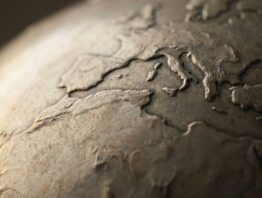 Nahaufnahme eines Metallglobus mit geprägten Kontinentumrissen