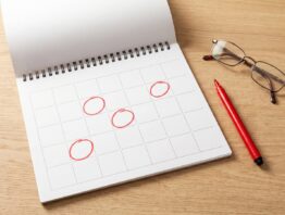 Wandkalender mit rot markierten Feiertagen und Filzstift