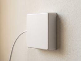 Kleines weißes Wandkästchen mit seitlich eingeführtem Kabel