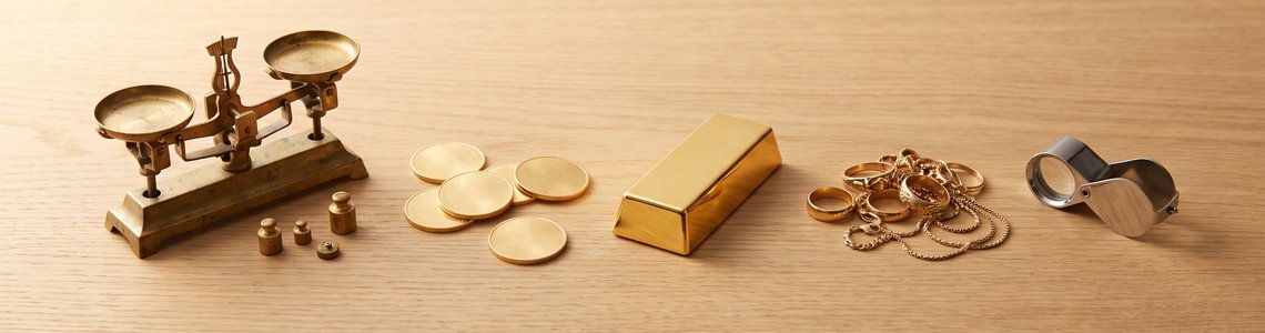 Gold verkaufen 2026 - Goldschmuck, Anlagemuenzen und Feinwaage auf einem Schreibtisch