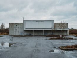 hellweg insolvenz bild 1 Großer Baumarkt am Stadtrand mit leerem Parkplatz und Einkaufswagen bei bedecktem Himmel