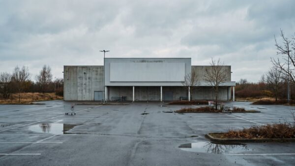 hellweg insolvenz bild 1 GroĂer Baumarkt am Stadtrand mit leerem Parkplatz und Einkaufswagen bei bedecktem Himmel