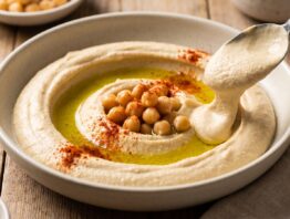 Cremiger selbstgemachter Hummus mit Olivenoel in Schale