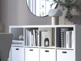 Weißes KALLAX Regal mit Büchern und weißen Boxen in einem Wohnzimmer