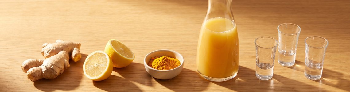 Zutaten fuer Ingwer-Shot selber machen auf Holztisch