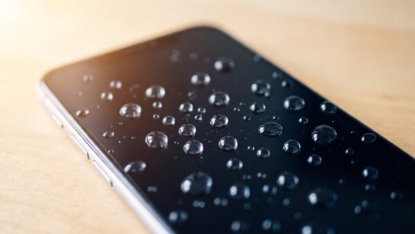 Wassertropfen perlen auf dem Display eines Smartphones