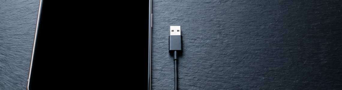 Halb aufgeklapptes faltbares Smartphone auf dunkler Schieferfläche