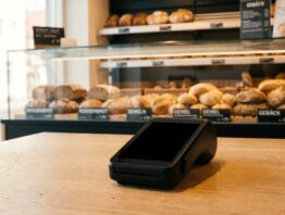 Kartenterminal mit schwarzem Display auf dem Tresen einer Bäckerei