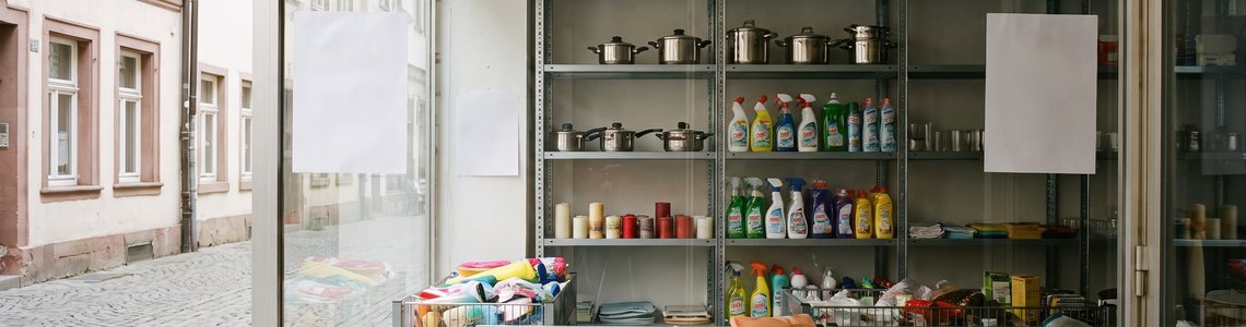 Schaufenster eines Haushaltsdiscounters mit halb leeren Regalen und Wühltischen