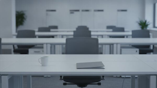 krankschreibung medizinischer dienst bild 2 Leerer Schreibtisch mit zurĂĽckgeschobenem BĂĽrostuhl in einem hellen GroĂźraumbĂĽro