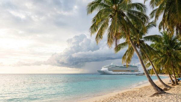 Karibische Bucht mit Kreuzfahrtschiff vor Anker und aufziehender Wolkenfront