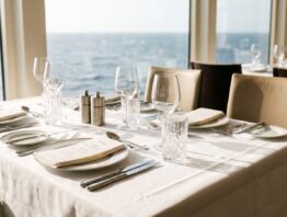 Gedeckter Tisch im Bordrestaurant eines Kreuzfahrtschiffs mit Meerblick
