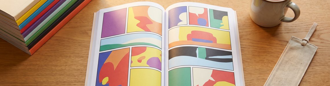 Stapel bunter Comic-Taschenbücher auf dem Schreibtisch – Lustiges Taschenbuch Abo